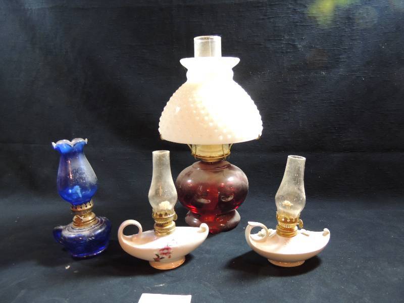 lot 201 image: Ruby Red oil Lamp with white hobnob shade and chimney 14 H, 2 porcelain Aladdin lamps made in Japan and blue glass lamp with handle 8