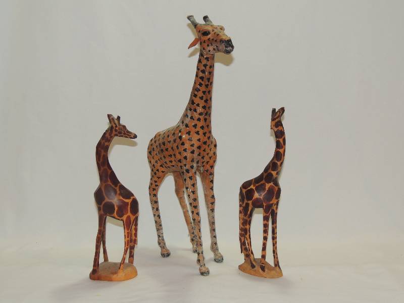lot 181 image: GIRAFFES - Qty 3,    18 tall with cloth covering   Wood caned giraffe x 2 (one missing part of head. It was a tragedy, don�t ask)