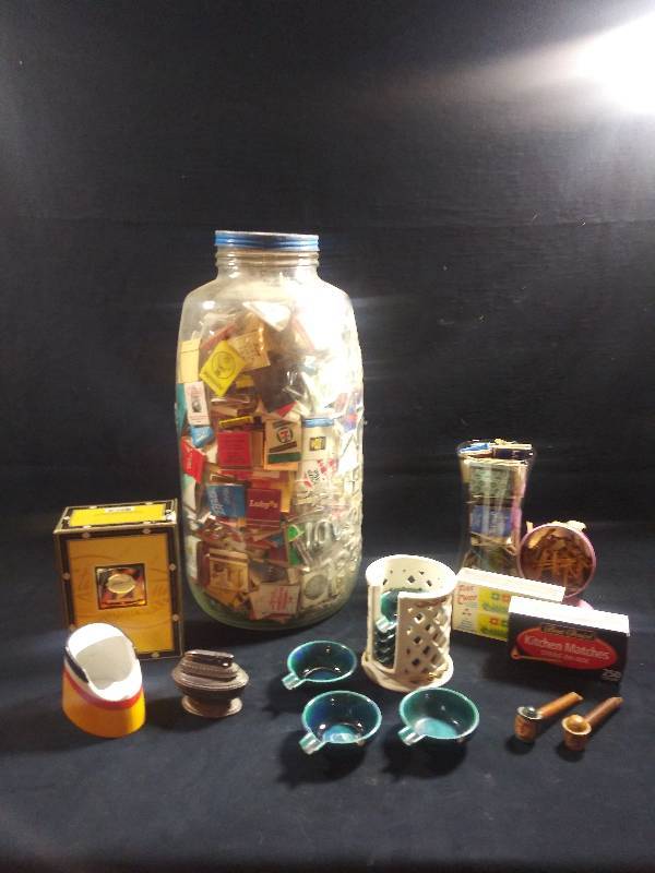 lot 37 image: Matchbook collection and smoking accessories- 5 Gal Jar (MASONS  PATENT NOV. 30 1858) FULL of assorted matchbooks, matches boxes, 2 small pipes with mens faces, 7 Aqua ashtrays stacking in white storage container HAPAG cigar ashtray and Ronson lighter