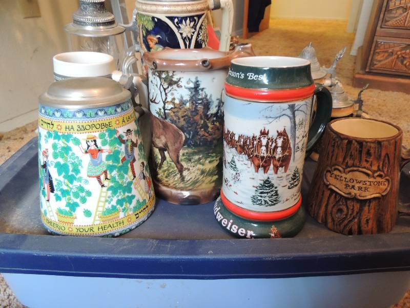 lot 258 image: Steins and Tankards- Tankards are Budweiser, Yellowstone, Irish, and deer. Steins are all German 1 is very tall and one is cut glass