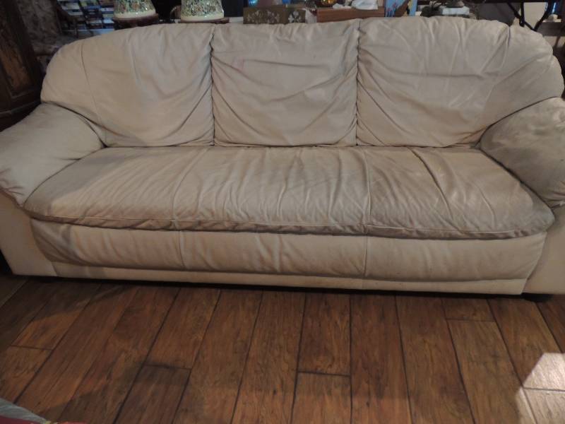 lot 233 image: Leather couch and love seat. Ivory color. Does have some wear and marks on it comes with several throw pillows