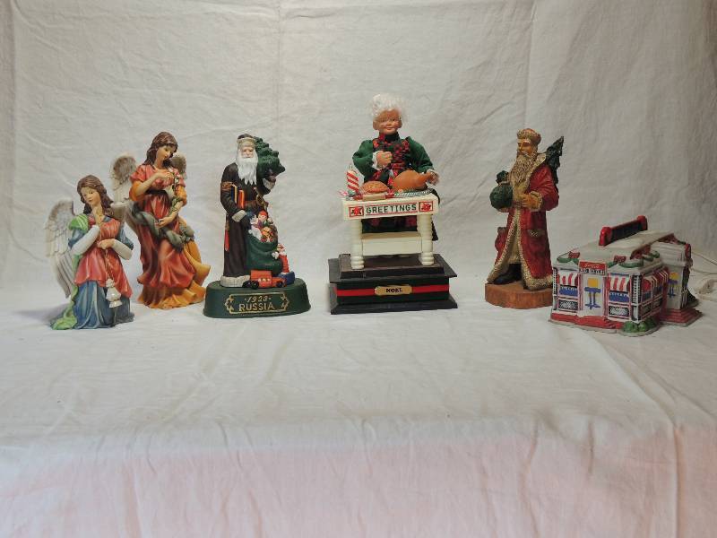 lot 438 image: Grandeur Noel Large Nativity Angels,   House scene Mrs. Clause with Turkey , Santas of the world Russia 1923,  Lighted house Coca Cola Diner and Santa WINSOR Collection