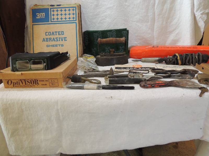 lot 486 image: Railroad spike- United fund 1885 Panama Canal Railroad,   Optivisor,  sandpaper 4 packages,  vise grips metal scissors,  soldier iron by American Beauty,  Sad iron