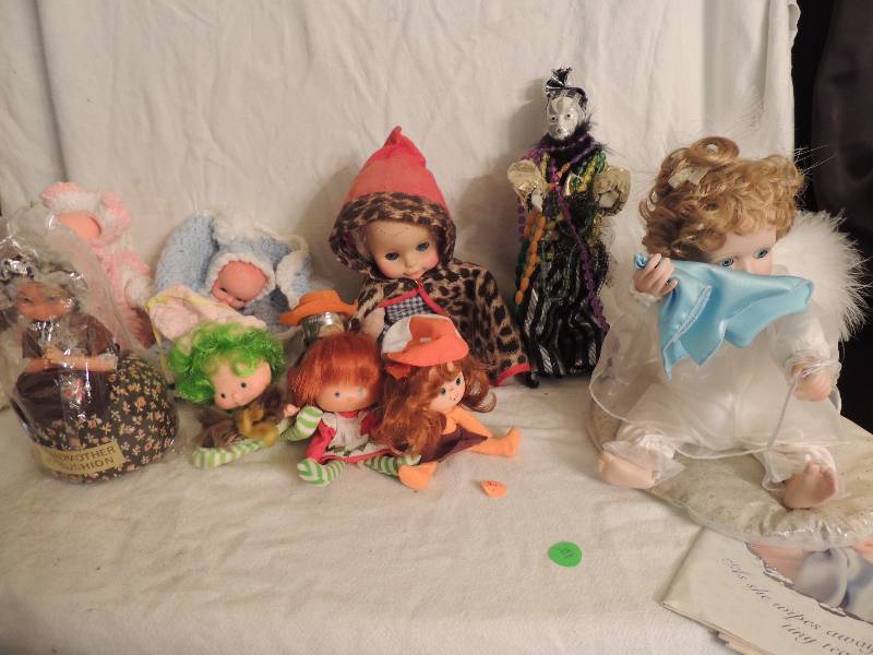 lot 89 image: Ashton Drake Collector doll with paper work, Every Cloud has a Silver Lining 9 tall, Mardi Gras doll 10, 3 Strawberry Shortcake dolls 3 tall, Pin cushion doll with  cape 10 and male & female crochet