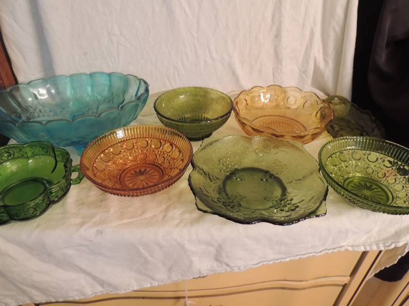 lot 57 image: Blue glass fruit bowl, 3 emerald green glass bowls, amber glass bowl, ruby red glass plate, Carnival glass platter, blue 4  glass bowl  and two 4 red hand blown pitchers