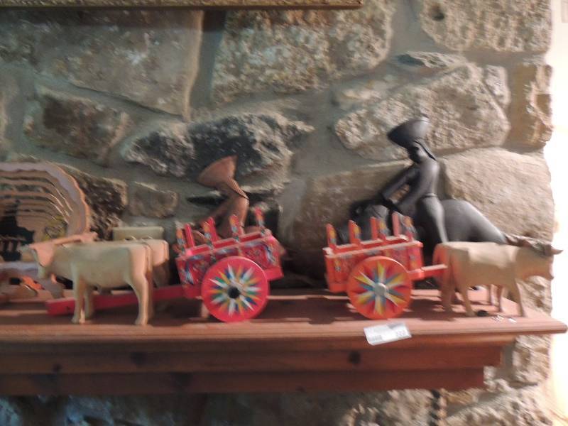 lot 222 image: Wooden carving of bull and matador black set and teakwood set,  MINITURE Costa Rica ox carts with oxen. Orange and red color very colorful cart length is 16 x8x7