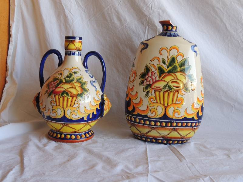 lot 748 image: 2 decorative vases  -  1 has handles on the side- tall vase is chipped  at the top by opening.    Small handle vase 12 12 tall   Large vase 14 tall