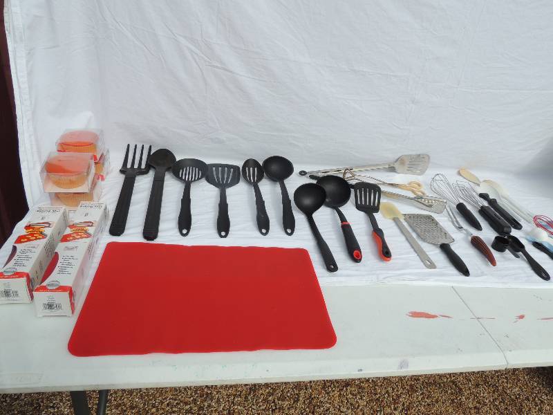 lot 803 image: Misc. Kitchen lot includes mixing spoons, soup, ladles spatulas cheese shredder, measuring spoons, grill spatula, cup cake reusable cupcake baking cups. Kitchen aid baking mats 9 11 and 14