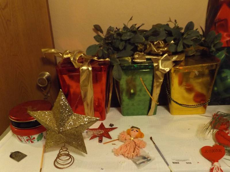lot 909 image: Christmas- gifts boxes, flowers, can 2 trays, gold angel tree topper, red and green baskets, centerpiece and 3 Christmas boxes