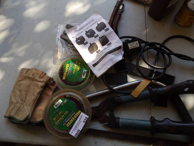 lot 938 image: Weed eater line, bush trimmers, hand saw, garden gloves, fountain pump
