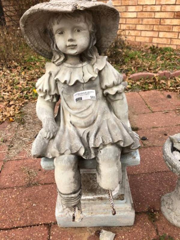 lot 988 image: Concrete statue of little girl with hat sitting on stool has some wear and tear on legs