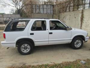 lot 25 image: 1998 GMC JIMMY CASH ONLY ON THIS ITEM ALL WINDOWS WERE BLOWN OUT DURING RECENT TORNADO GREAT PARTS TRUCK OR TO FIX BACK UP. CASH ONLY SALE