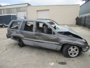 lot 27 image: 1999 GRAND CHEROKEE LAREDO SMASHED BY TORNADO BLUE TITLE. CASH ONLY ON THIS ITEM