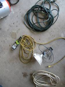 lot 24 image: 1 50FT. EXTENSION CORD, 1 10FT EXTENSION CORD, CORDED SHOP LIGHT AND 1 CLIP ON LIGHT