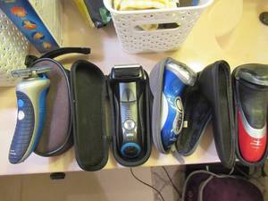 lot 50 image: 3 NORELCO ELECTRIC RAZORS WITH PIVOTING HEADS, 1 BRUAN ELECTRIC RAZOR ALL HAVE CHARGING BASES AND COMES WITH HANGING BACK OF DOOR BAG