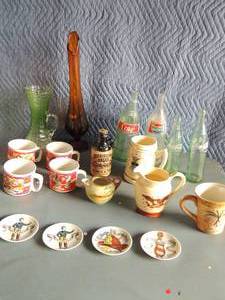lot 128 image: Various decorative bottles(coke and Pepsi 4 Campbells soup mugs, Mississippi mud  black & tan beer bottle Eagke spout with handle container and more 4 jockey hitching post plates 1881-1890