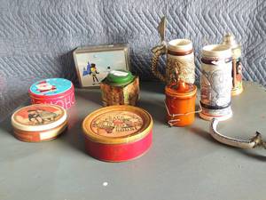 lot 131 image: Various tins including Planters peanuts Peace be in this house, christmas, brown cheese crock, with latch, 3 Avon stein (one has broken handleand lid pieces are there