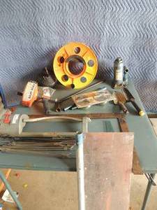 lot 149 image: 2 levels  ,extension cordwinder ,  hand hydrolic jack 2      plumber snakes, water sprinkler    paint shield and more