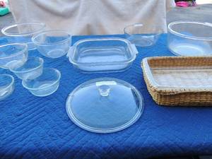lot 86 image: 2 Pyrex oven dishes with wicker basket holders, 6 various size Pyrex mixing bowls, rival 2 qt. oven baker and glasbake sunbeam mixing bowl