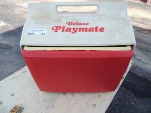 lot 195 image: Red and white delux playmate ice chest with various tools and more inside ( breakers,conduit connectors, lamp fixtures, light switch covers and electrical plugs