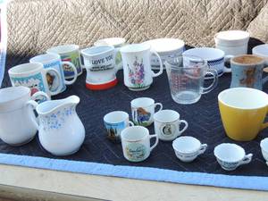 lot 199 image: Mini souvenir cups from Carlsbad, D.C., New Orleans, the Ozarks and large cups with sayings like Law Poulet, Florida, Rosters, chickens, bears Campbells soup and more. 1 being fire king