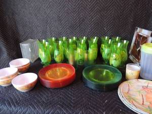 lot 259 image: 15 plastic Hawaiian cups 14 plastic green plates 15 plastic orange plates 5 plastic Hawaiian bowls 4 plates1 cup and a plastic pitcher with lid