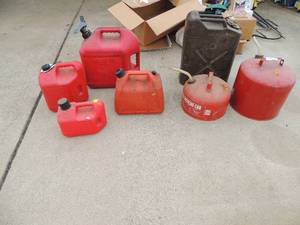 lot 49 image: 7 various sizes of gas cans 1 gal up to 5 gal 2 are metal the rest plastic