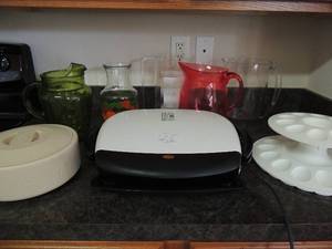 lot 130 image: Double decker deviled egg holder green tea pitcher red Kool-Aid pitcher, lean mean grill tortilla warmer various other pitchers