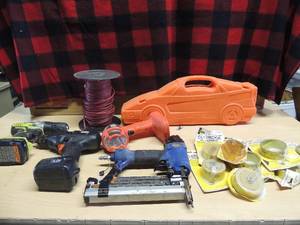 lot 202 image: Campbell air staple gun, car shape tool kit, black and decker light no charger 6 volt t B&D power drill Ryobi power drill no charge roll of red wire, multiple tape measures and replacement rolls