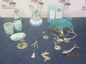 lot 222 image: TOTAL OF 12 DOLPHIN FIGURINE HOME DECOR&nbsp&nbspWIND CHIMES ,TIMEX PORCELAIN GLASS DOME MANTEL SHELF CLOCK ,&nbsp DOLPHIN TALKING RADIO,VINTAGE MELTED PLASTIC BLUE DOLPHIN TABLE TOP NIGHT LIGHT , DOLPHIN BATHROOM SET AND MORE SEE PIC&nbsp