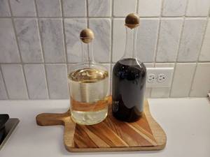 lot 179 image: Cutting Board & Sealed Bottles of Liquids