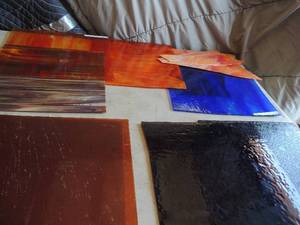 lot 405 image: Stained glass lot-Marble 12x12, Andrew orange 12x13, orange story 13x12, dark red 12x12, purple 13x12, blue 11 x 12 and 3 orange broken pieces