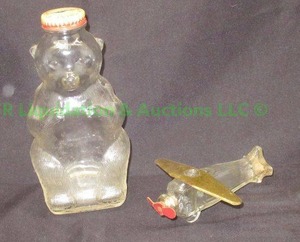 lot 100 image: Vintage T.H. Stough Co. glass candy pellet airplane and Snowcrest beverages glass bear bottle coin bank