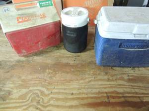 lot 509 image: Blue Rubbermaid ice chest, Black Coleman water cooler and red playmate drink chest