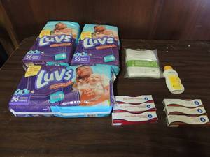 lot 703 image: 3 bottles of zinc oxcide ointments, 3 bottles of vitamin A&D ointment, weleda baby oil, 3 pack of organic body suits 3 packs of size 1 luvs diapers