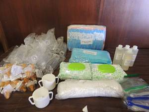lot 705 image: 3 J&J baby wash, 1 bottle angel of mine baby wash, 10 baby spoons, 2 packs of premium wipes, 15 wash cloths, 20 plus simulac bottles with ready use nipples 20 under pads members mark, 34 pack 4T-5T pull-ups and 2 Sippy cups