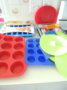 lot 28 image: Silicone baking - new bar pan, cupcake x 2 pans, 8x8 pan, 3 sets of baking cups Crofton silicone lids 9 and 11set of 2 new, 8 set of 3, and cake pan 8