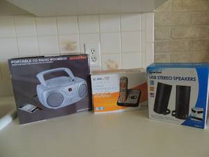 lot 56 image: ATT Cordless phone NIB, Connect land USB speakers NIB, Sylvania portable radio boom box used but in original box