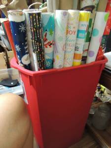 lot 124 image: Red trash can full of Christmas paper and gift bags, blue tote full of Christmas greenery, bows, ribbon, name tags etc.