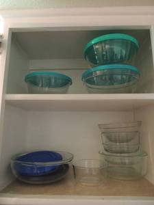 lot 13 image: Pyrex storage bowl 2 cup, Anchor Hocking bowls 1 qt., 1.5 qt., 2 qt., all with lids. Three 1 qt. bowls with lids and one 2 qt. casserole.