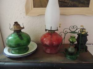 lot 24 image: Green oil lamp, red and white oil lamp, small oil lamp with gold top, light green oil lamp with brown middle piece