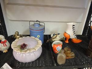 lot 50 image: Porcelain powder jar with lid, glass duck, gold and silver angel figurine, small blue crock, orange and black glass boot, brass flower pros with stick and more
