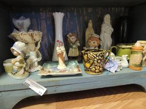 lot 77 image: Little porcelain dolls , praying Jesus, mini stein Norco Japan statue hour glass creamer dish and more.