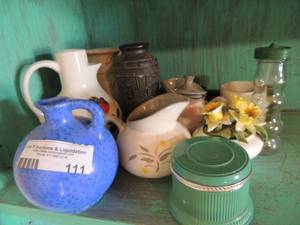 lot 111 image: Oil lantern with stained glass patterns, blue handled jug 8, pink covered milk jug, yellow and gray creamer and more