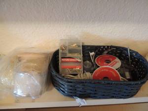 lot 170 image: Green wicker basket full of sewing supplies (needles, thread, ribbon, hooks, etc.