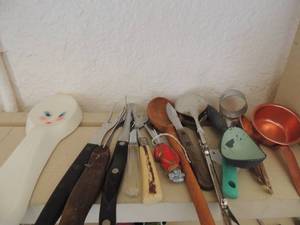lot 226 image: Spoon rest butter and jam knifes, measuring spoons, wooden spoon Boston red handle butter  knife and steak knives