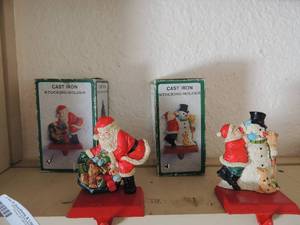 lot 397 image: 2 NIB Cast Iron stocking holders 1 is Santa & one is snowman