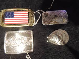lot 552 image: buckles-silver clam  shell, LRS initial with double haul truck, Stadler MFG. co. silver with flower tooling, and solid brass Heritage American flag