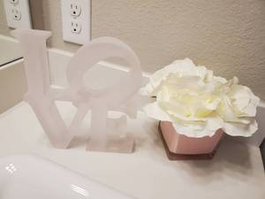 lot 116 image: Light Pink Acrylic LOVE & White Faux Flowers in Pink Vase