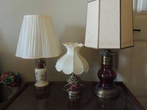 lot 9 image: 3 vintage lamps- 1 milk glass with floral dcor has shade 24 H, pink lamp with shade 16H, Red lantern lamp oil design with shade 27H.